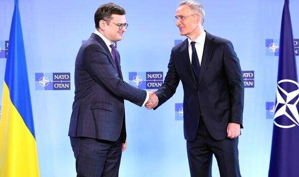 Le secrétaire général de l'OTAN, Jens Stoltenberg, à droite, serre la main de Dmytro Kuleba