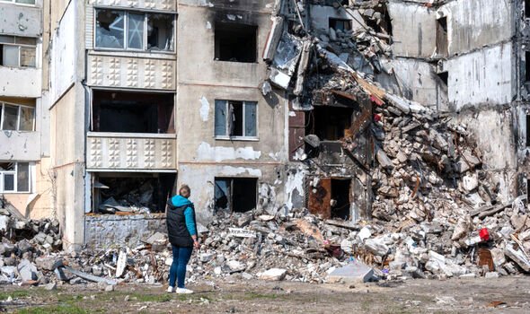 Un citoyen inspecte un immeuble résidentiel partiellement détruit dans le quartier Saltivka de Kharkiv