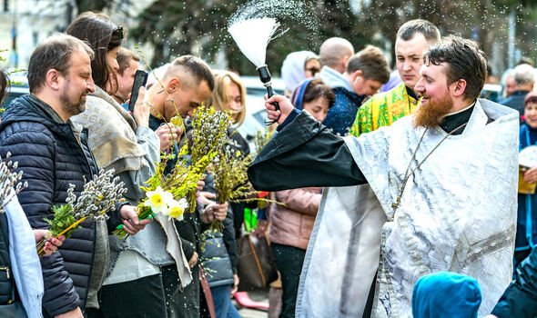 Un prêtre de la cathédrale Saint-Volodymyr bénit le public avec de l'eau bénite à Kiev 