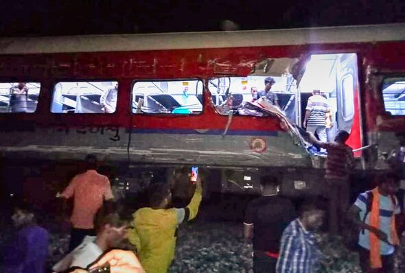Des personnes inspectent le site du déraillement d'un train de passagers dans le district de Balasore, dans l'État d'Orissa, dans l'est de l'Inde, vendredi (Press Trust of India/AP).